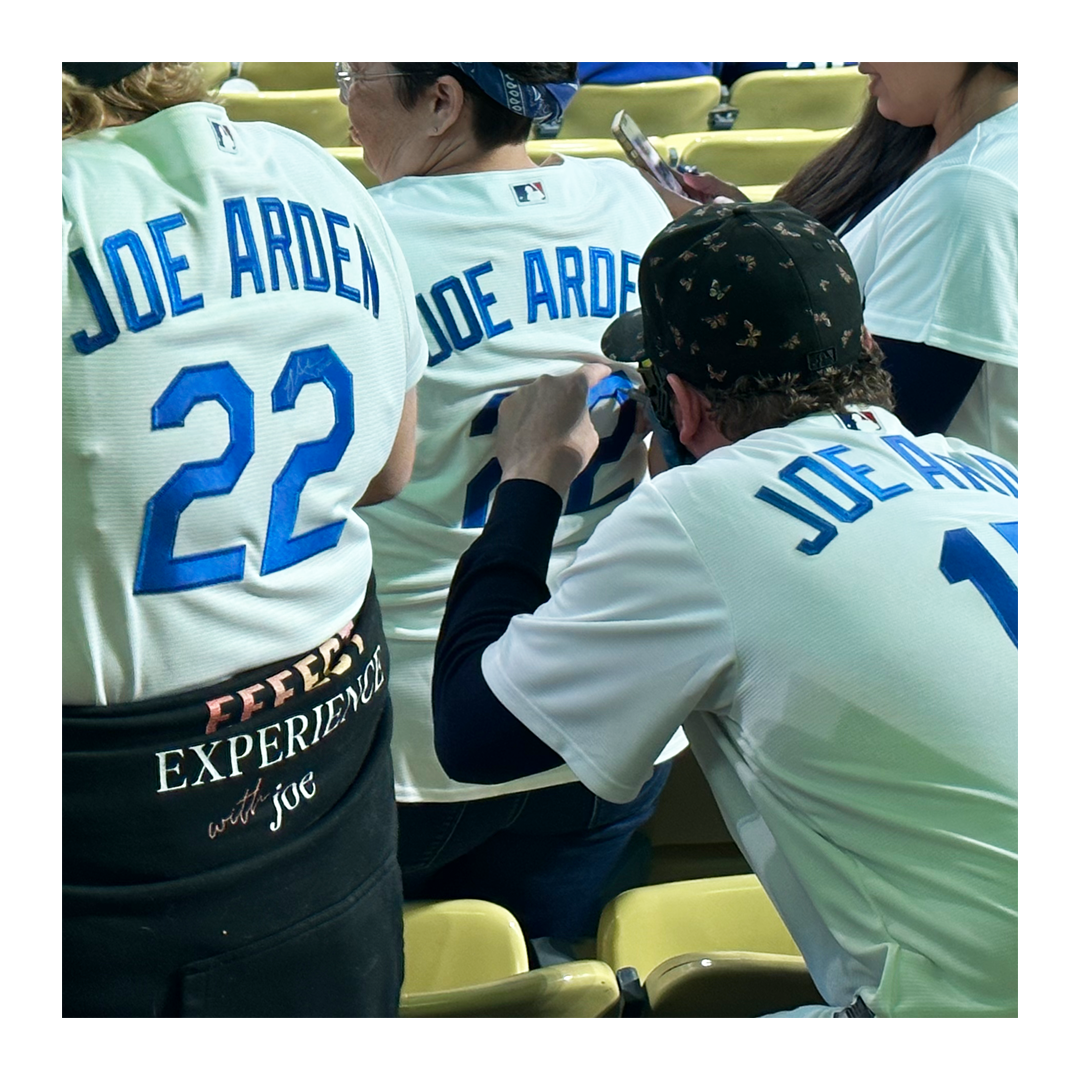Picture of Joe in his Joe Arden Jersey signing other Jerseys at the baseball game